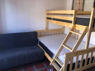 a room with two bunk beds and a couch at Apartamento funcional cerca a Parque de Bello Antioquia in Bello