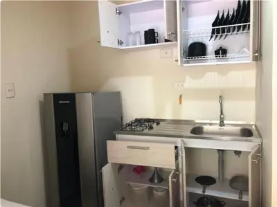 a small kitchen with a sink and a refrigerator at Apartamento funcional cerca a Parque de Bello Antioquia in Bello