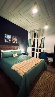 a bedroom with a large green bed in a room at Casa Mosaiko Sonsón in Sonsón