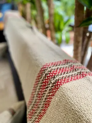 a close up of the edge of a couch with red and white threads at Casa Mosaiko Sonsón in Sonsón