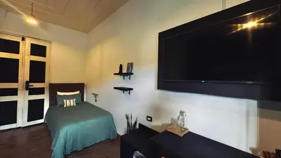 a living room with a large flat screen tv on the wall at Casa Mosaiko Sonsón in Sonsón
