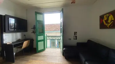 a living room with a green door and a couch at Casa Mosaiko Sonsón in Sonsón