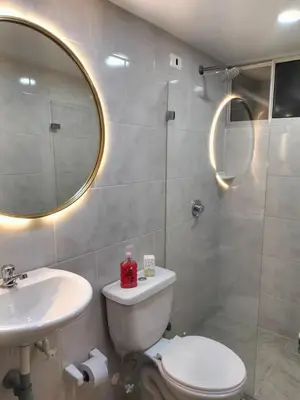 a bathroom with a toilet and a sink and a mirror at Tu espacio cómodo, elegante y céntrico con balcón 401 in Medellín