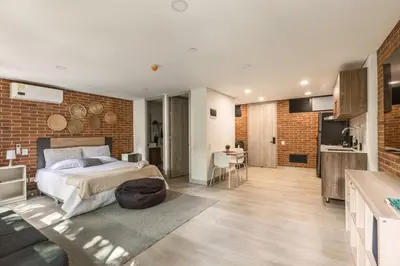 a bedroom with a bed and a brick wall at Kyux Building, Style and Comfort in Medellín
