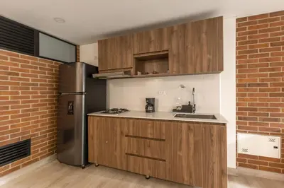 a kitchen with wooden cabinets and a stainless steel refrigerator at Kyux Building, Style and Comfort in Medellín