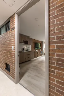 an open door into a kitchen with a brick wall at Kyux Building, Style and Comfort in Medellín