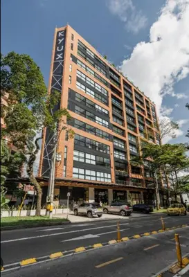 a tall building with cars parked in front of it at Kyux Building, Style and Comfort in Medellín