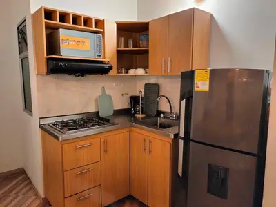 a kitchen with a stainless steel refrigerator and wooden cabinets at Ambiente natural y amplio, con vista panorámica de Medellín 501 in Medellín