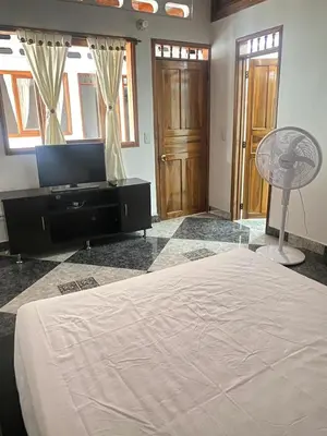a bedroom with a large bed and a fan at Casa MAVA in Mariquita