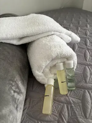 two bottles of moisturizers and a towel on a bed at Apto 201 2H 2B Belén Fátima MUY bien ubicado in Medellín