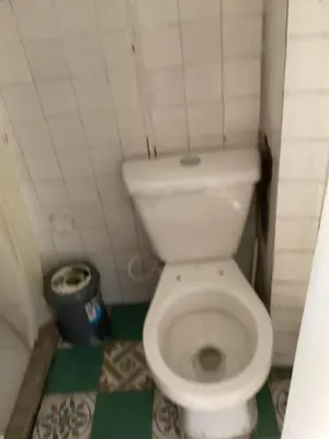 a small bathroom with a white toilet and a trash can at Las Hamacas Mountain Hostal zona de camping in Villamaría