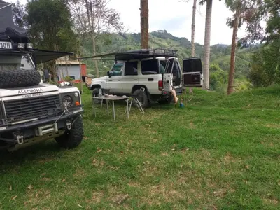 a truck parked in a field with a tent at Las Hamacas Mountain Hostal zona de camping in Villamaría