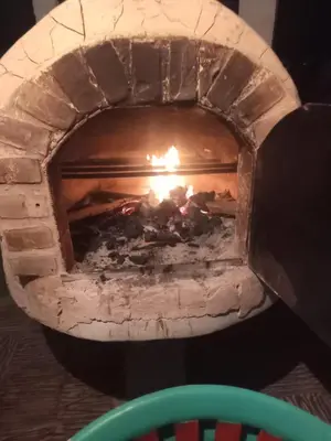 a brick oven with a fire in it at Las Hamacas Mountain Hostal zona de camping in Villamaría