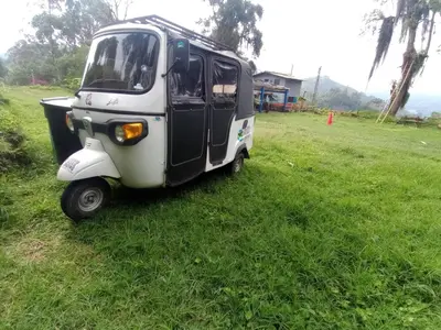 a small car parked in a field of grass at Las Hamacas Mountain Hostal zona de camping in Villamaría
