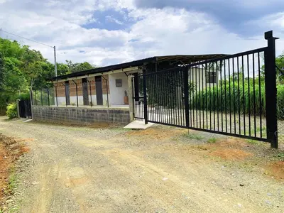 an iron gate in front of a small house at Eco Finca El Guadual - casa completa in Manizales