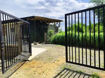 a gate in a yard next to a house at Eco Finca El Guadual - casa completa in Manizales
