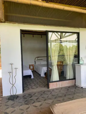 a bedroom with a bed and a glass door at Eco Finca El Guadual - casa completa in Manizales