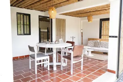 a dining room with a white table and chairs at Eco Finca El Guadual - casa completa in Manizales