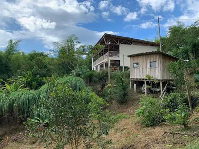 a house on the side of a hill with trees at Eco Finca El Guadual - casa completa in Manizales
