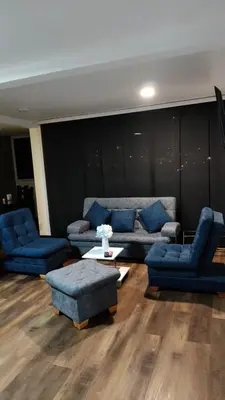 a living room with blue couches and a table at Apartamento cerca Terminal de Transportes y Cable aéreo in Manizales