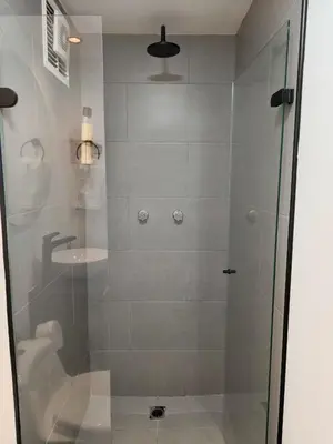 a shower with a glass door next to a sink at Apartamento cerca Terminal de Transportes y Cable aéreo in Manizales