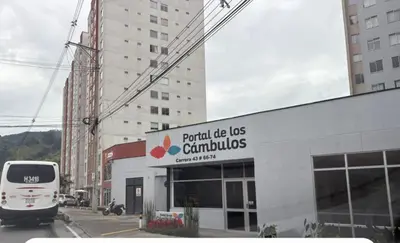 a bus is parked in front of a building at Apartamento cerca Terminal de Transportes y Cable aéreo in Manizales