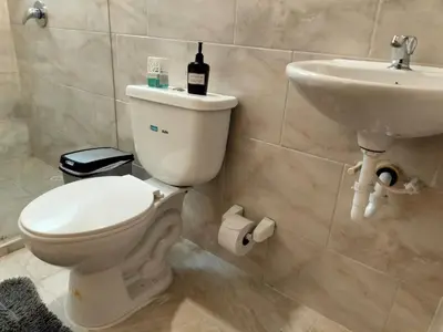 a bathroom with a toilet and a sink and a bottle of wine at Inspirado en Bali con espectacular vista 502 in Medellín