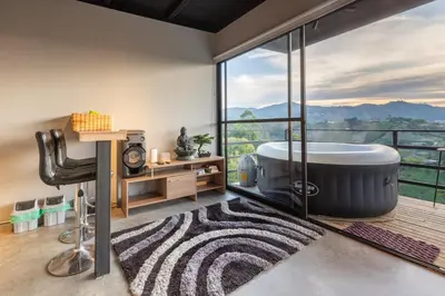 a bathroom with a large tub and a view of the mountains at Roots Eco House in Guatapé