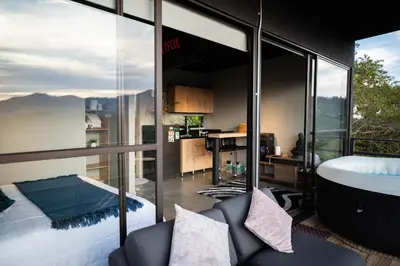 a bedroom with a view of a bathroom with a tub at Roots Eco House in Guatapé