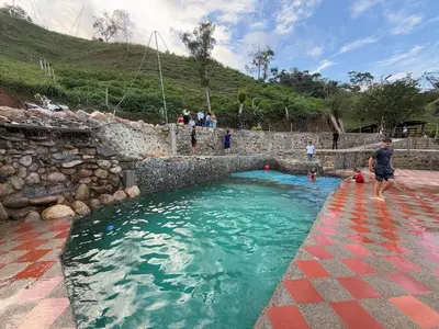 a man standing in a pool of water at Cabaña con jacuzzi y piscina con agua de manantial in Norcasia
