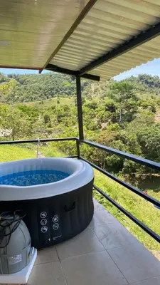 a hot tub on a balcony with a view at Cabaña con jacuzzi y piscina con agua de manantial in Norcasia