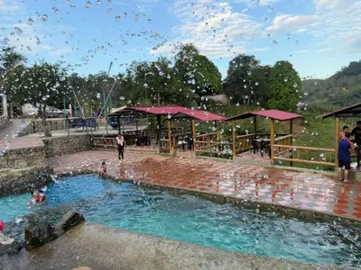 a pool of water with people playing in it at Cabaña con jacuzzi y piscina con agua de manantial in Norcasia