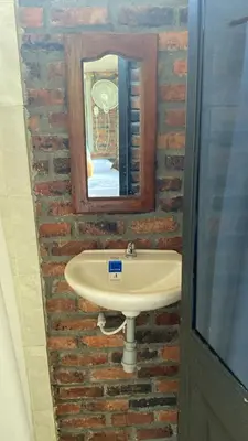 a bathroom with a sink and a mirror on a brick wall at Cabaña con jacuzzi y piscina con agua de manantial in Norcasia
