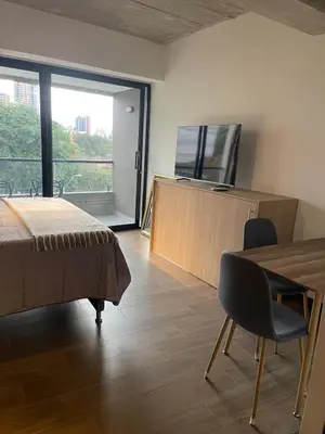 a bedroom with a bed and a table and a television at Apartment with a balcony El Tesoro in Medellín