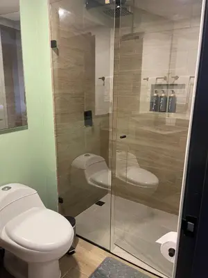 a bathroom with a toilet and a glass shower at Apartment with a balcony El Tesoro in Medellín