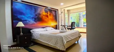 a bedroom with a large painting on the wall at COMODO APARTAMENTO WIFI-COWORK CERCA a ZONA TURISTICA DE MEDELLIN in Medellín