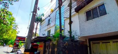 a building with a fence next to a street at COMODO APARTAMENTO WIFI-COWORK CERCA a ZONA TURISTICA DE MEDELLIN in Medellín