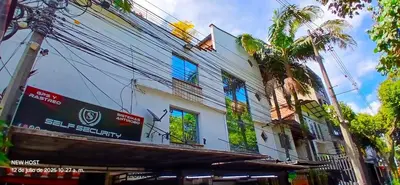 a white building with windows and a palm tree at COMODO APARTAMENTO WIFI-COWORK CERCA a ZONA TURISTICA DE MEDELLIN in Medellín