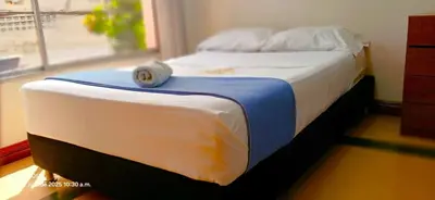 a bed with a hat sitting on top of it at COMODO APARTAMENTO WIFI-COWORK CERCA a ZONA TURISTICA DE MEDELLIN in Medellín