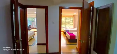 a room with two doors and a room with beds at COMODO APARTAMENTO WIFI-COWORK CERCA a ZONA TURISTICA DE MEDELLIN in Medellín