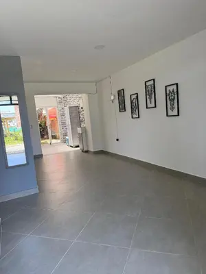an empty room with a tile floor and pictures on the wall at Primer piso con Garaje in Guatapé