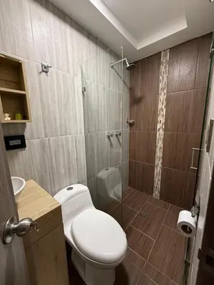 a bathroom with a toilet and a glass shower at Primer piso con Garaje in Guatapé