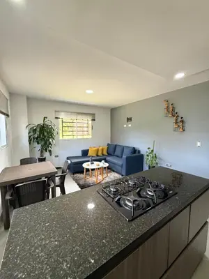 a kitchen and living room with a stove top oven at Primer piso con Garaje in Guatapé