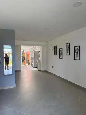 a room with white walls and a hallway with pictures on the wall at Primer piso con Garaje in Guatapé
