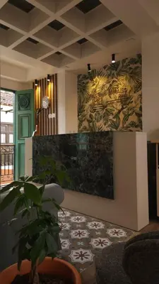 a living room with a plant and a wall with a painting at Paraíso Plaza - Hotel Boutique in Aguadas