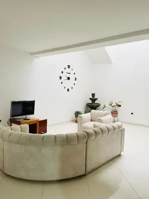 a living room with a couch and a clock on the wall at Apartamento Luz De Luna in Jardin