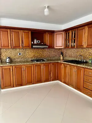 a kitchen with wooden cabinets and marble counter tops at Apartamento Luz De Luna in Jardin
