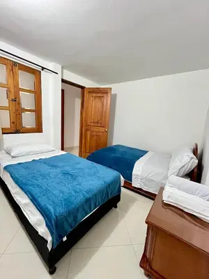 a bedroom with two beds and a table at Apartamento Luz De Luna in Jardin