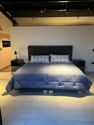 a bed with a blue comforter in a room at Cabañas DALI la catedral in Envigado