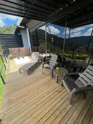 a wooden deck with chairs and a table at Cabañas DALI la catedral in Envigado